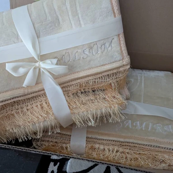 Zwei cremefarbene Gebetsteppiche mit Schleife als Geschenk